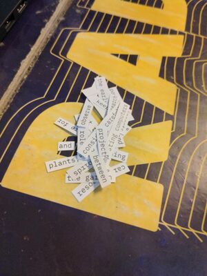 snippets of text on a table in the worm radio studio. they read for example "project", "between", "plants".